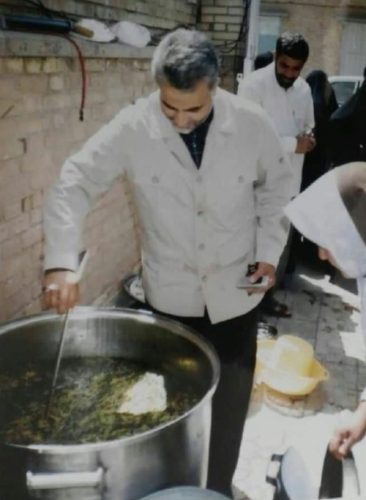 حاج قاسم در حال به هم زدن آش نذری